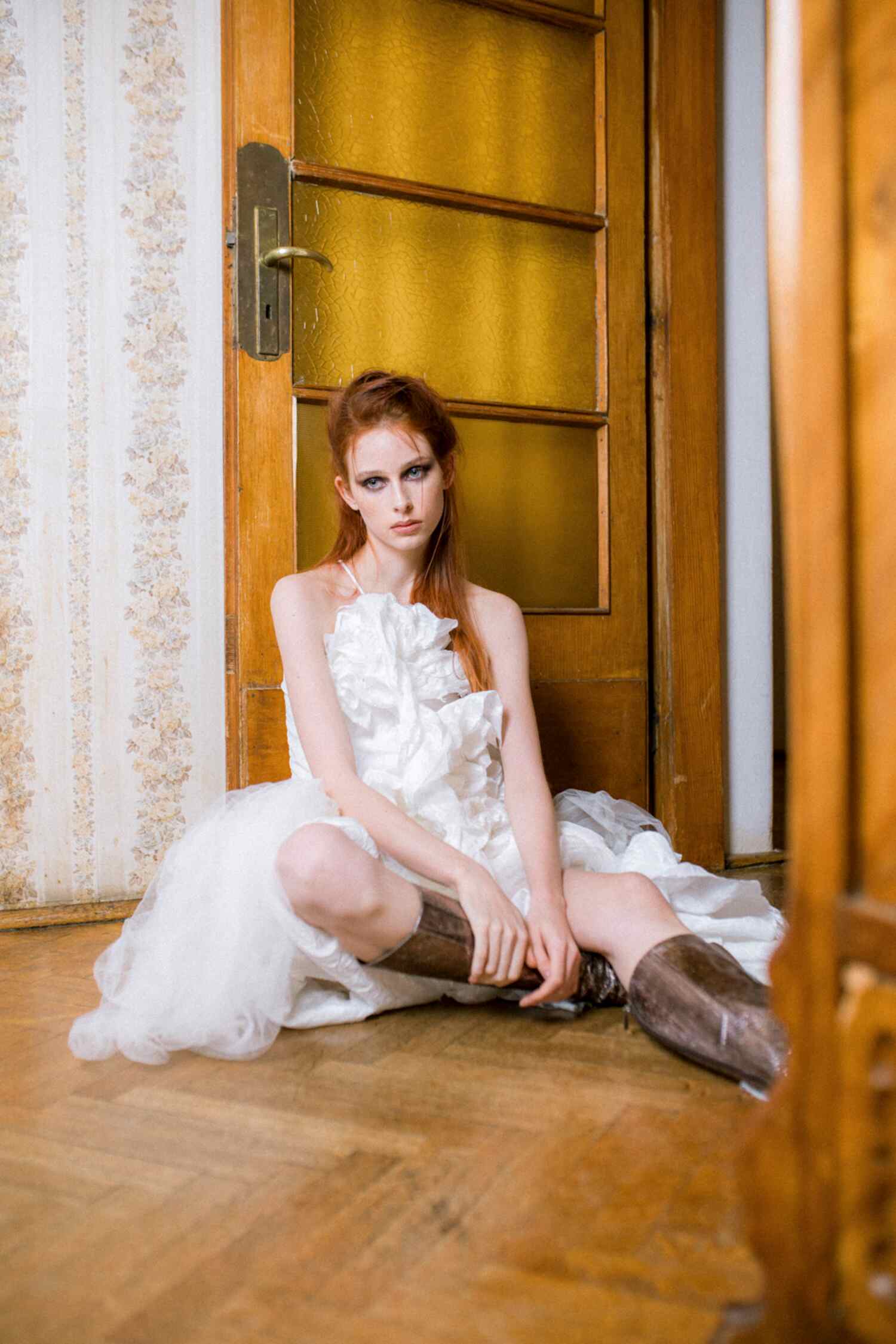 Model Weronika Siesicka wearing a dress by Magdalena Wilk-Dryło, Jimmy Choo boots, and a Dolce & Gabbana bag in a fashion editorial by Helena Bromboszcz.